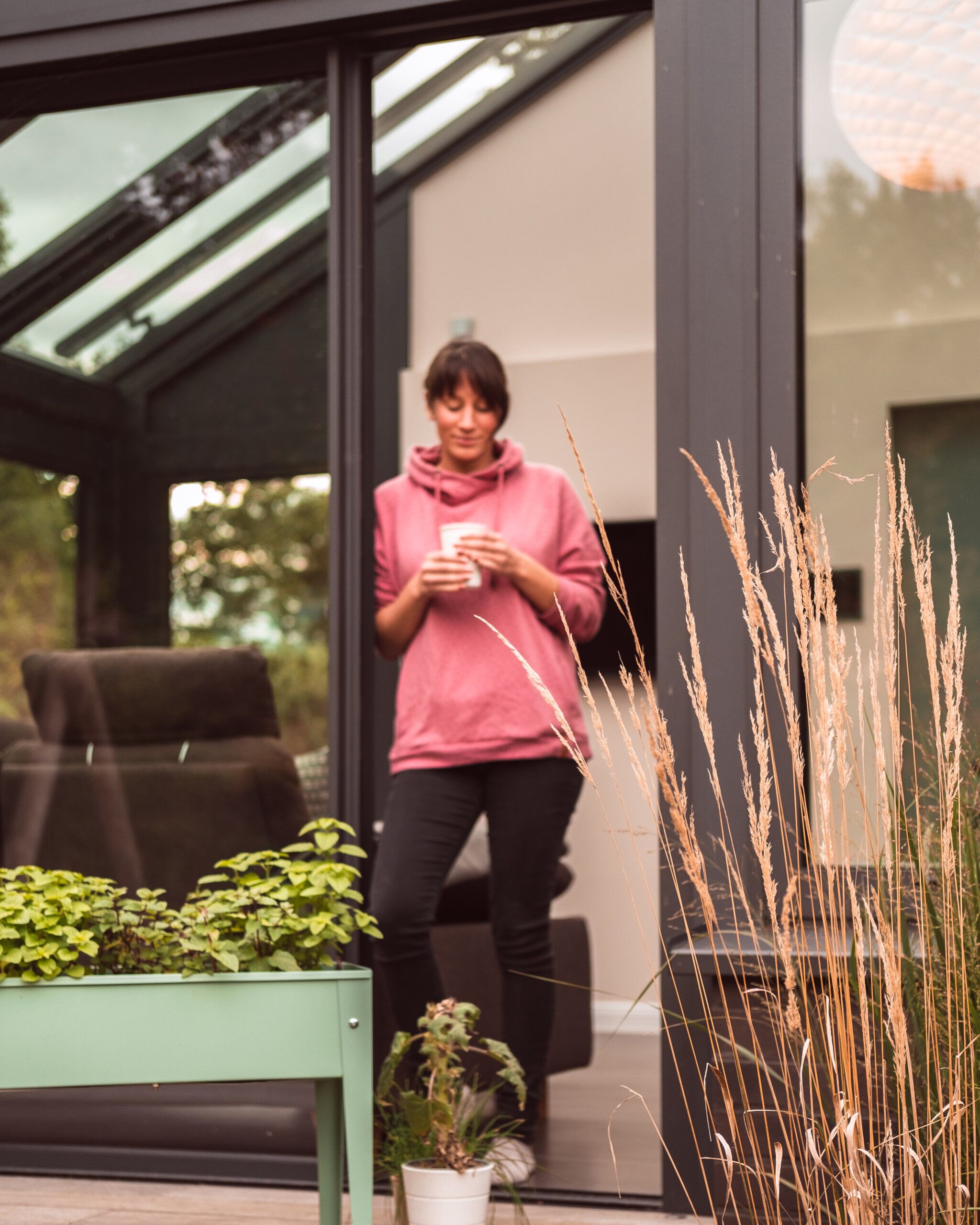 Galeriebild Beitrag Wintergarten von Solarlux – Wohlfühlen im Herbst Model mit Kaffee im Grünen von Sonne Rundum bei Hamburg
